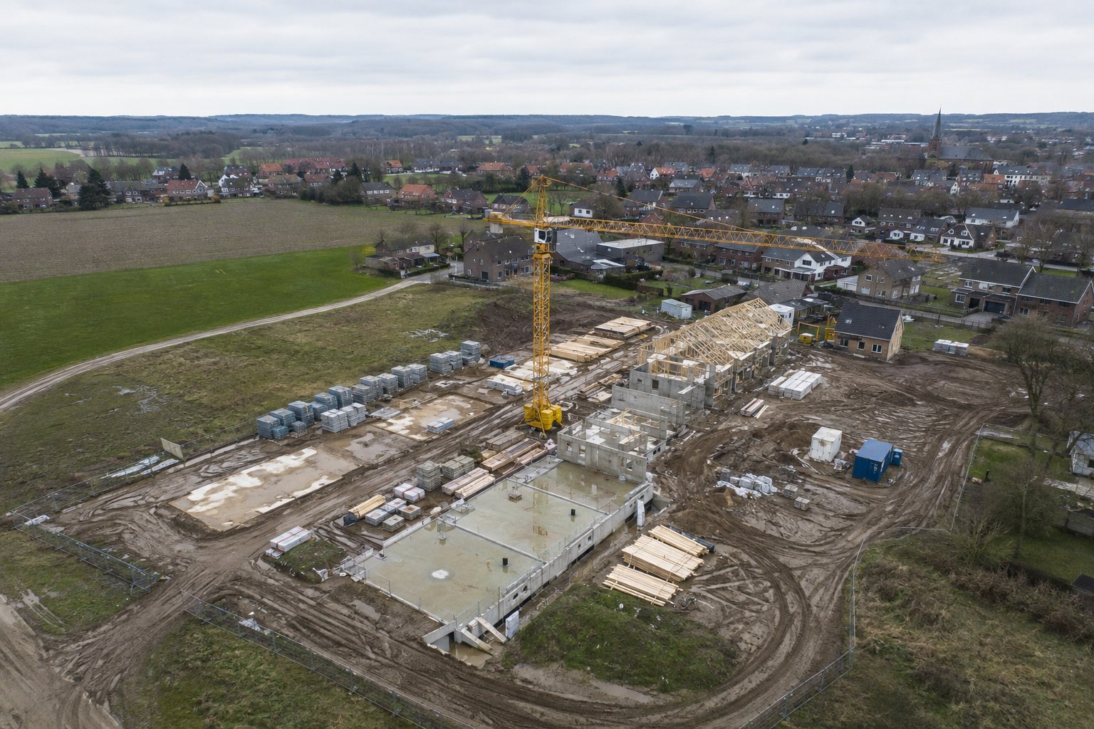 Voorbeeldvisualisatie van een luchtfoto van een bouwplaats met fundering, kraan en bouwmateriaal