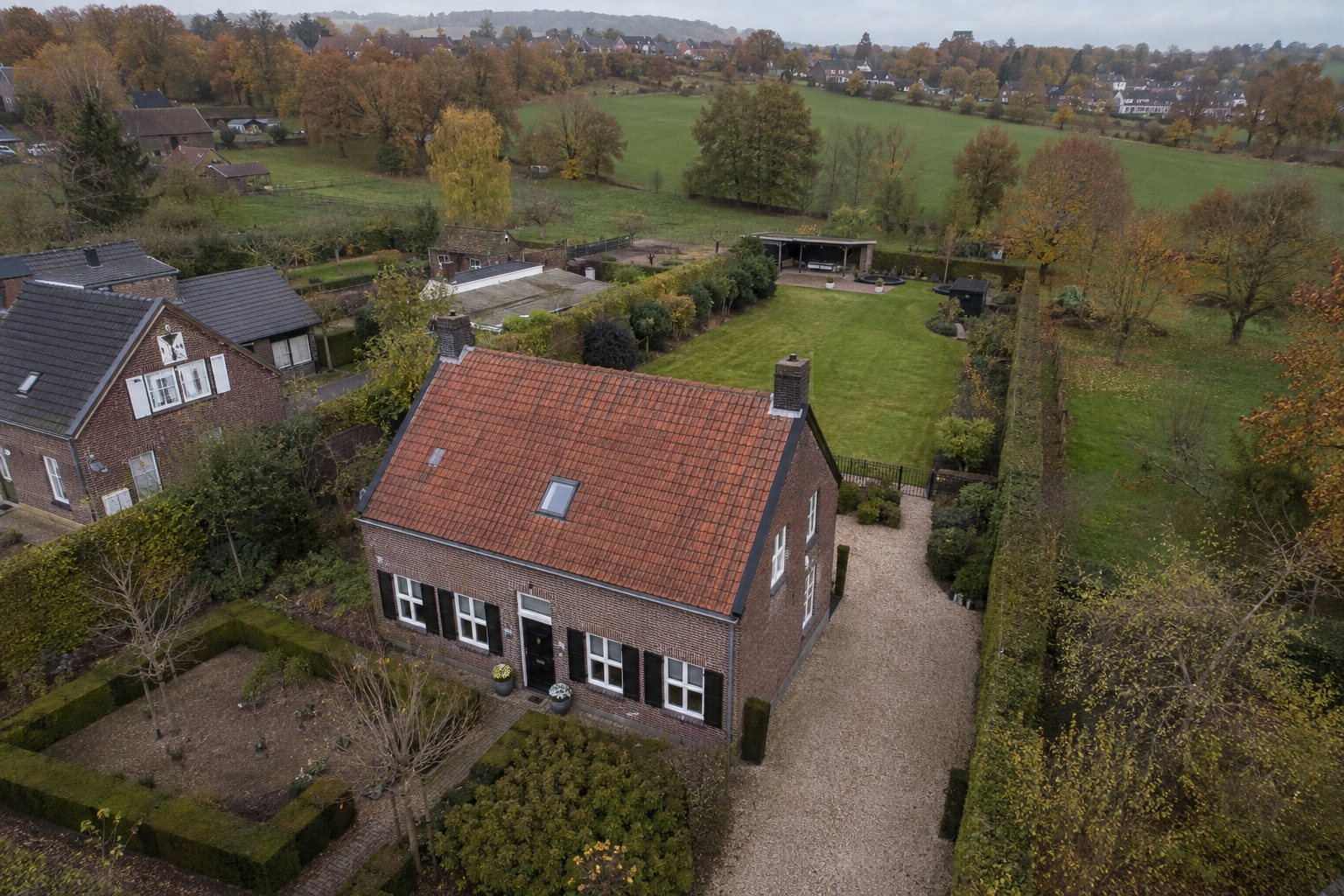 Voorbeeldvisualisatie van een luchtfoto van een vrijstaande woning met tuin in Limburg, schuin van boven